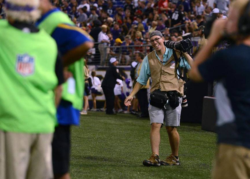 Baltimore Sun photo intern Al Drago dances after making an early deadline at the Baltimore Ravens vs. San Francisco 49ers preseason NFL game in Baltimore, M.D. in August 2014. Photo by Rachel Woolf.